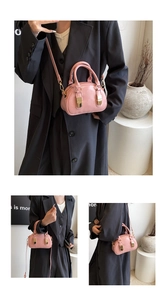Detailed view of pink mini bowling bag with gold buckles and adjustable strap