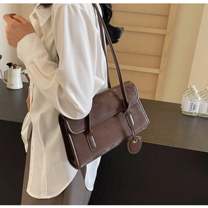 Detail of vintage brown underarm bag with double straps and textured faux leather finish
