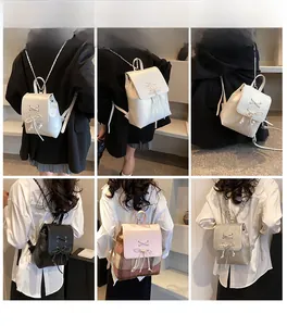 Showcase of four mini leather backpacks with bow details in white, black, silver, and pink