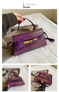 Dettaglio borsa Kelly viola in pelle coccodrillo con chiusura dorata e tracolla rimovibile