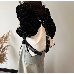 Détail du sac à bandoulière en cuir crème avec sangle noire et boucle argentée