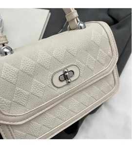 Detailed macro of cream rhombic leather texture and silver metallic twist lock closure
