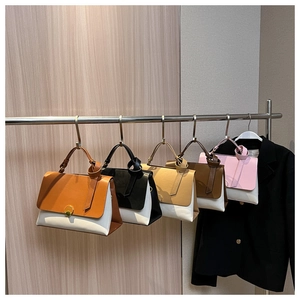 Detailed display of assorted contrast color faux leather handbags on a metal display rack