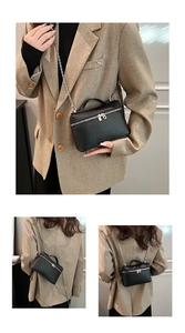 Detail showing the black litchi texture PU leather handbag with dual zippers and chain strap