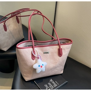 Detail view of pink matte tote bag with burgundy straps and star-shaped plush pendant