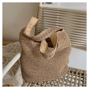 Gros plan détaillé de la texture du sac cabas en paille tressée avec bandoulière
