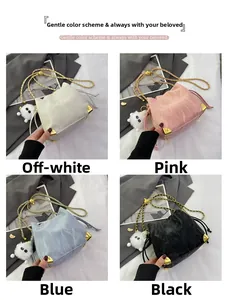 Dettaglio di quattro borse a secchiello in bianco, rosa, blu e nero con angoli in metallo