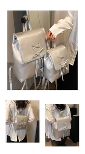 Detail view of silver metallic drawstring backpacks with bow knots and ribbon straps
