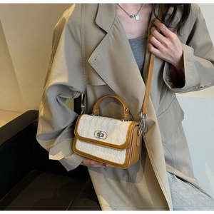 Close-up of a color-block quilted crossbody bag styled with a classic beige trench coat