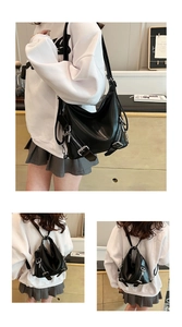 Vue détaillée du sac hobo en cuir verni noir avec fermetures éclair et boucles argentées