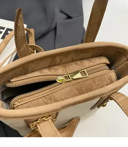 Détail du sac cabas kaki avec fermeture éclair dorée et texture cuir froissé premium