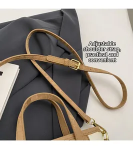 Détail de la bandoulière réglable en cuir marron clair avec boucle dorée pour sac à main