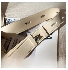 Detail of adjustable off-white leather strap with silver pin buckle and fine stitching