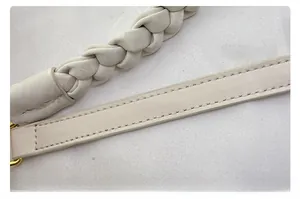 Détail de la bandoulière en cuir blanc cassé avec texture tissée et métal doré