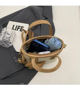 Intérieur spacieux du sac seau beige avec rangement pour téléphone, parapluie et maquillage