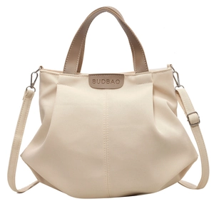 Minimalist beige canvas tote bag with brown leather handles and adjustable shoulder strap