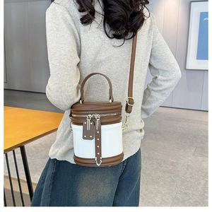 Rear view of a model wearing the white and brown color-block cylinder crossbody bag