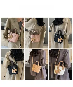 Détail du mini sac cabas tendance avec breloque chiot en rose, noir, jaune et beige