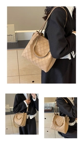 Detail of quilted tote bag with golden ring handle and detachable leather strap