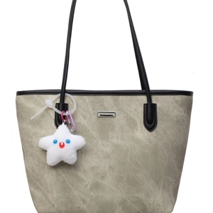 Fashionable grey-green tote bag with black leather handles and star plush accessory
