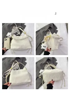 Vue détaillée du sac seau blanc montrant le cordon latéral et le similicuir texturé