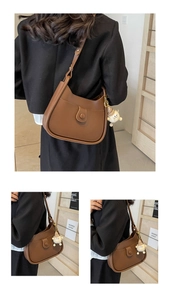 Detail of dark brown leather saddle bag with decorative front pocket and plush monster charm