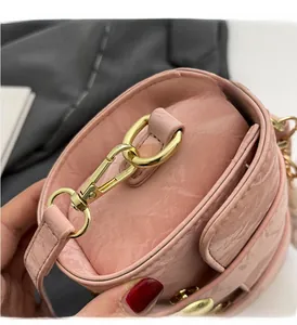 Detail of pink small square bag with glossy wave texture and gold hardware clasp