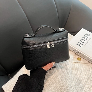 Minimalist black pebble leather satchel bag with silver hardware and top handle for women