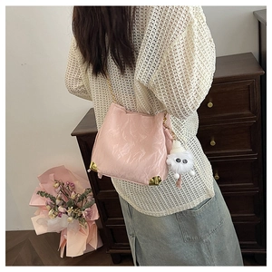 Dettaglio borsa tote rosa con trama arricciata, angoli dorati e ciondolo in peluche