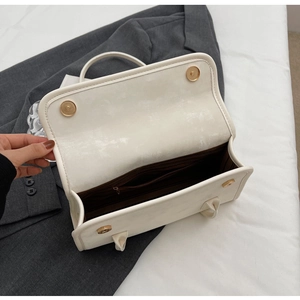 Detailed interior of a white PU leather handbag with magnetic buckles and inner zipper pocket