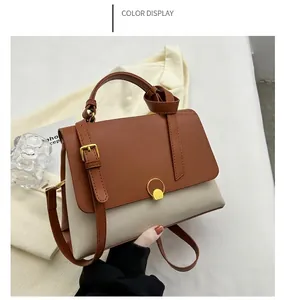 Detailed shot of brown and off-white shoulder bag with gold ring buckle and PU leather texture