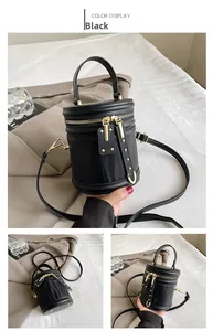 Detail of black cylinder bucket bag featuring wave-textured PU leather and gold studs