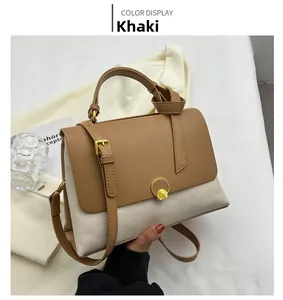 Close-up of khaki and cream leather patchwork handbag with gold ring lock and top handle