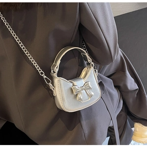 Silver metallic mini crossbody bag with metal bow detail and elegant chain strap