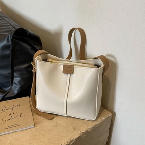 Borsa a secchiello alla moda color crema con cinturini in pelle marrone, vista lifestyle