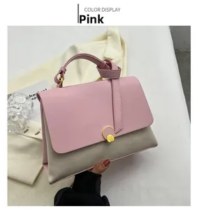 Detail view of pink and grey contrast shoulder bag with a round gold metallic buckle
