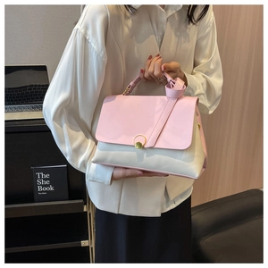 Detailed view of pink and beige contrast leather handbag with gold round buckle fastener