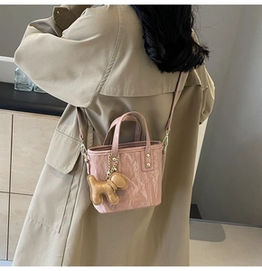 Vue détaillée du sac seau à motif marbre rose avec un charmant pendentif chiot