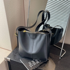 Elegante borsa a secchiello in pelle nera con cuciture e ampia tracolla comoda