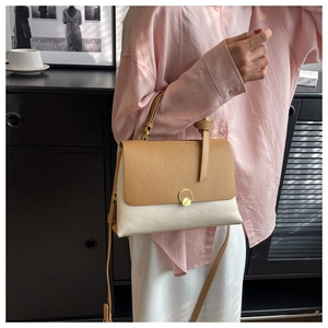 Minimalist cream and khaki color-block handbag with golden ring buckle on a model