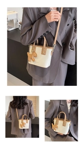 Détail du sac seau crème et kaki avec breloque chiot et bandoulière amovible réglable