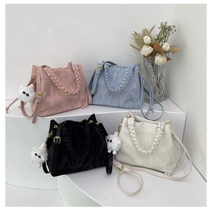 Détail de sacs seaux colorés à texture nuage avec poignées tressées et charmes mignons