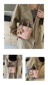 Détail du sac seau en cuir plissé rose avec breloque chien et lettrage doré de mode