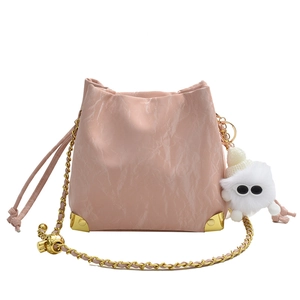 Borsa tote rosa stropicciata con catena dorata e simpatico ciondolo mostro bianco