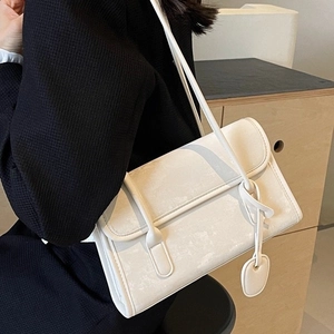 Minimalist white underarm bag with marble texture and knot detail on a black outfit