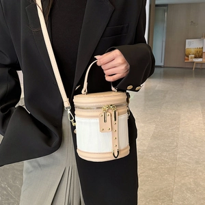Chic beige and white cylindrical bucket bag with wavy texture and golden hardware