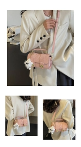 Pink embossed satchel bag with plush lamb charm and adjustable strap shown on model