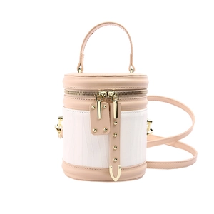 Pink and white cylindrical bucket handbag with textured fabric and gold hardware