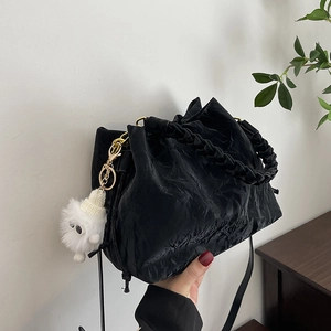 Sac seau noir plissé chic avec poignée tissée et un joli charme de poupée en peluche