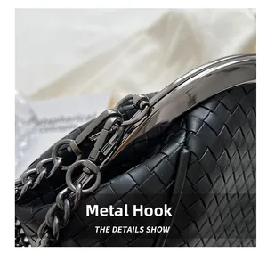 Close-up of black woven leather handbag showing metal chain strap and gunmetal hardware